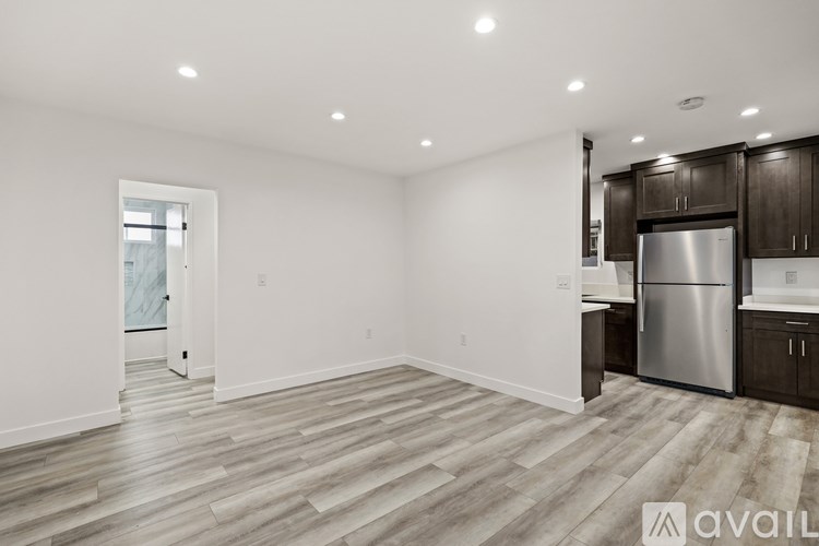 A spacious kitchen with a refrigerator, sink, and cabinets.