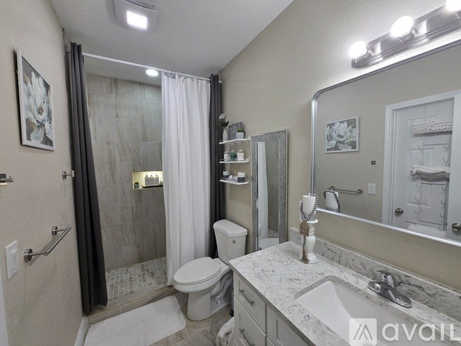 A bathroom with a toilet, sink, and shower.