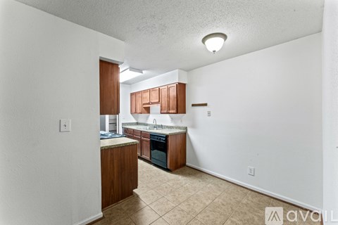 A kitchen with wooden cabinets and a tiled floor.