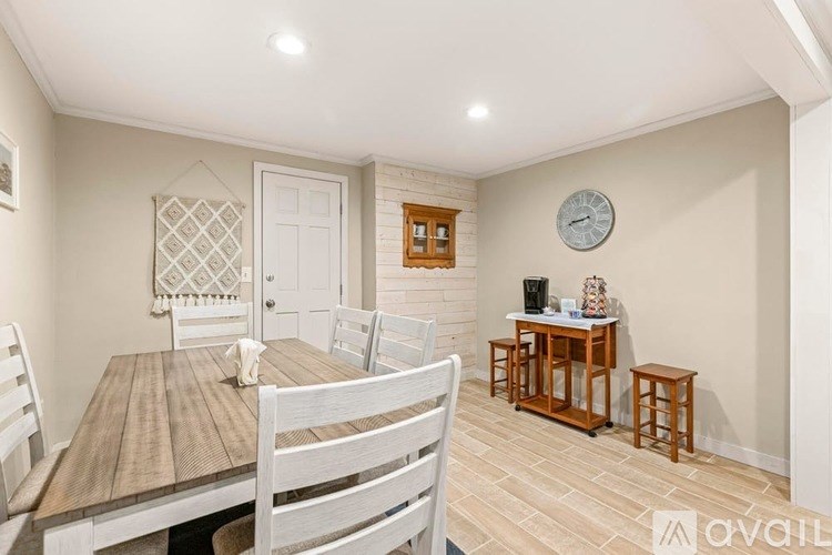 A dining room with a wooden table and chairs.