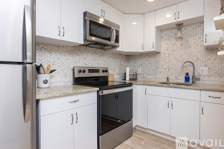 A kitchen with white cabinets and a black oven.