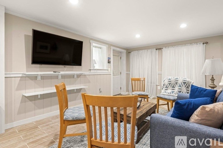 A living room with a television, chairs, and a couch.