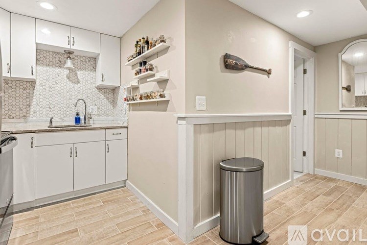 A kitchen with white cabinets and a tiled backsplash.