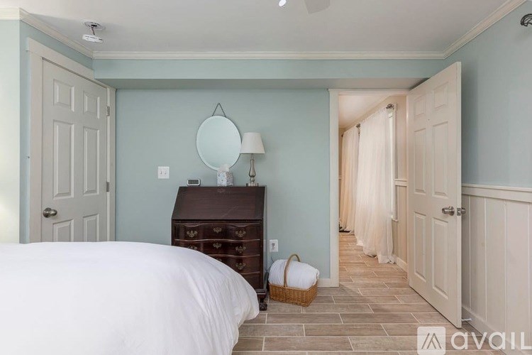 A bedroom with a bed, dresser, and mirror.