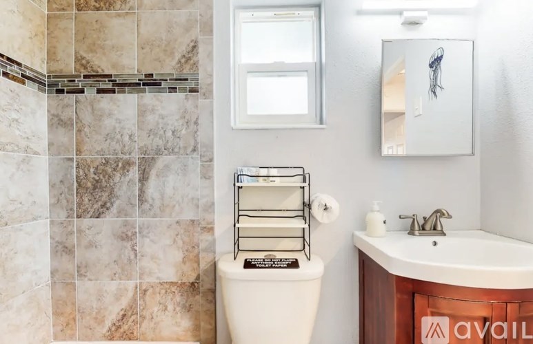 A bathroom with a toilet, sink, and mirror.