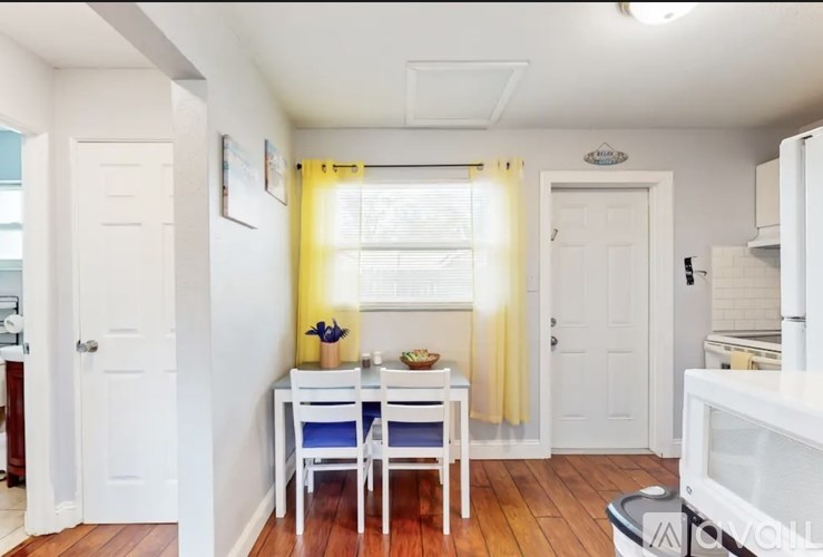 A kitchen with a table and chairs in the middle of the room.