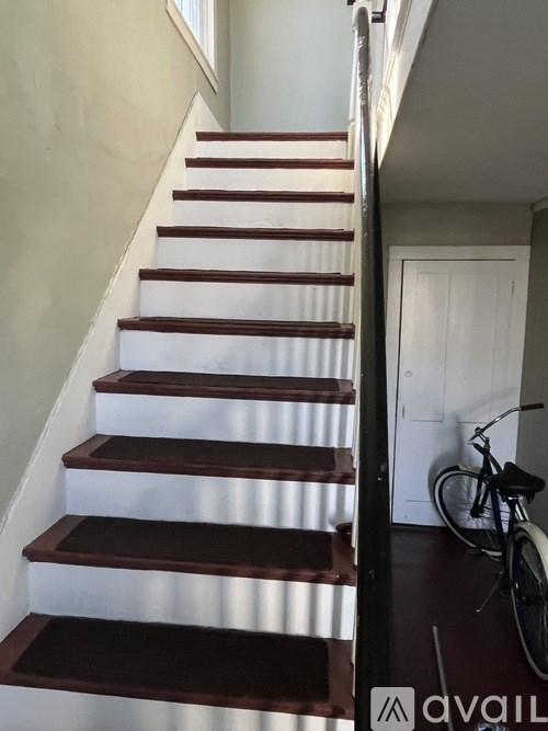 A room with a black TV and a black trash bin.