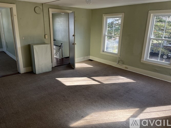 A bathroom with a toilet, tub, and window.