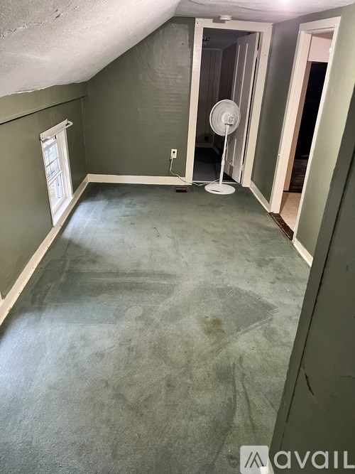 A room with a fan and a window.