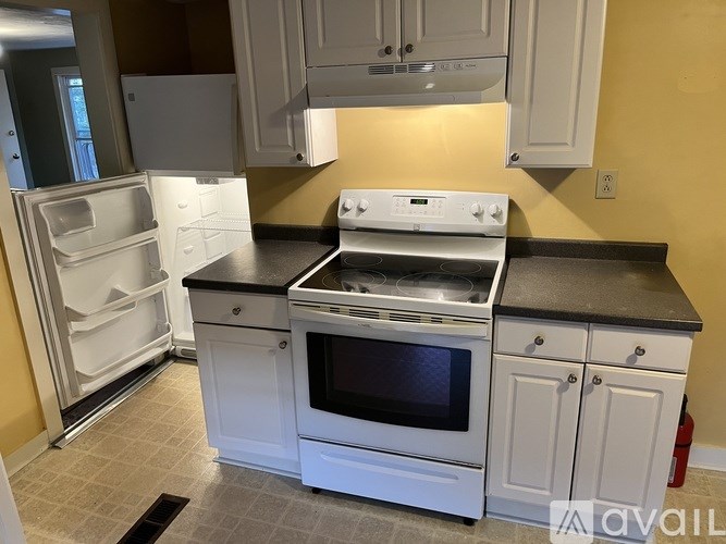 A kitchen with white appliances and cabinets.