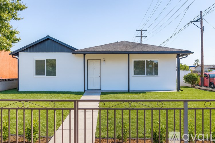 A white house with a black roof and a blue stripe on the side.
