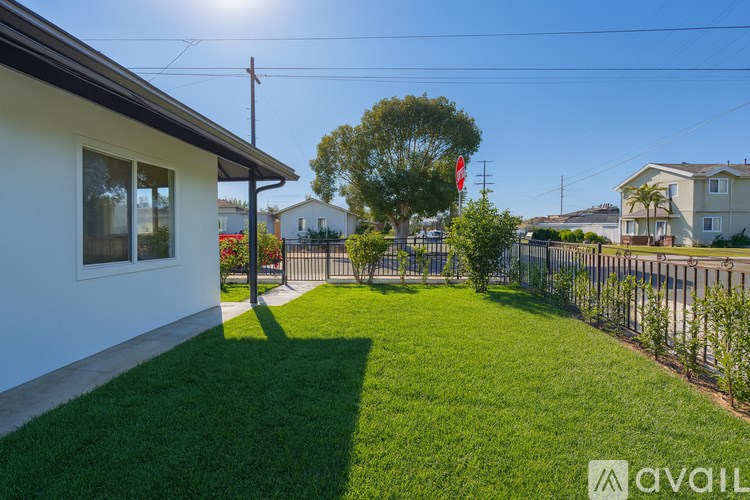 A house with a white exterior and a green lawn in front.