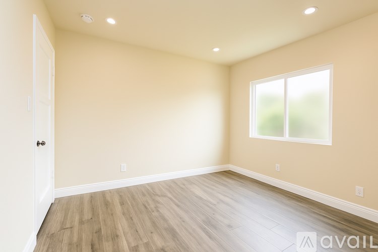 A room with wooden flooring and a window.
