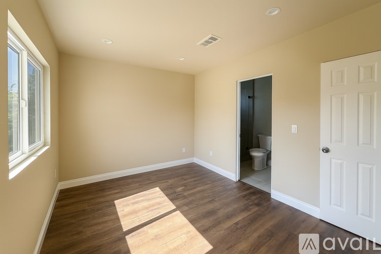 A room with a wooden floor and a white door.