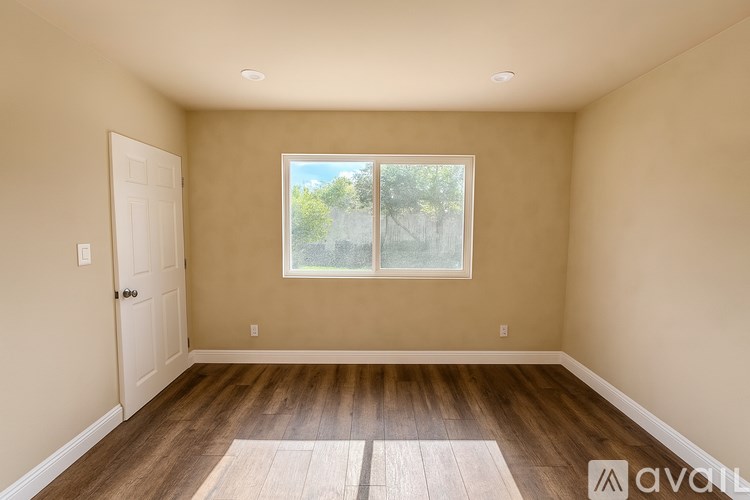 A room with a window and wooden floors.