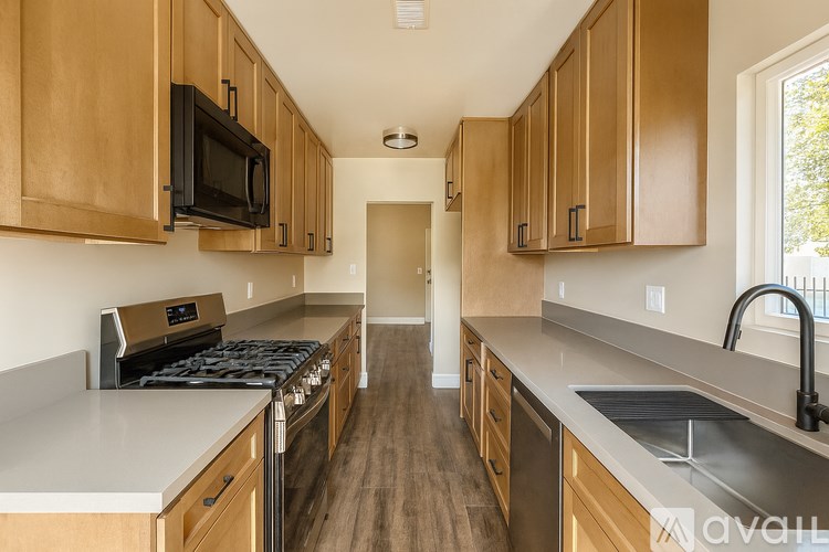 A kitchen with wooden cabinets and a stove top oven.