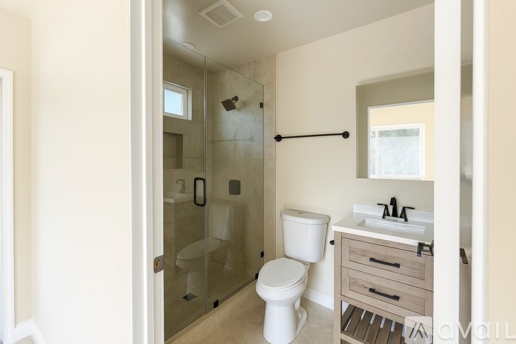 A bathroom with a toilet, sink, and shower.