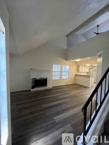 A living room with a fireplace and a staircase.