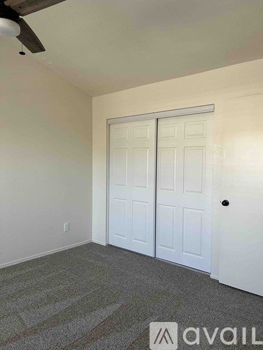 A room with a carpeted floor and a white door.
