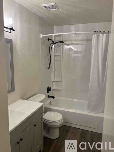 A white bathroom with a toilet, sink, and bathtub.