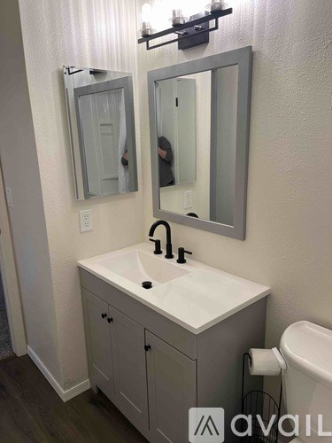 A bathroom with a sink, mirror, and cabinet.