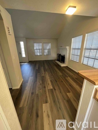 A room with wooden flooring and white walls.