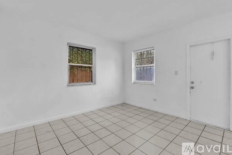 A room with a tiled floor and two windows.