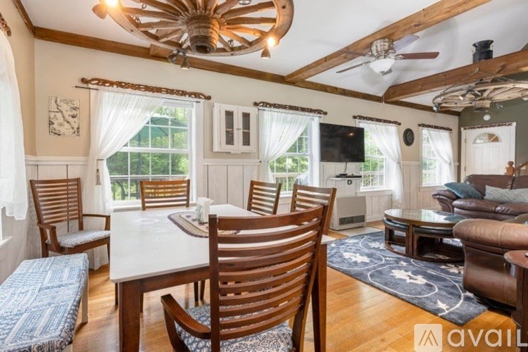 A dining room with a wooden table and chairs.