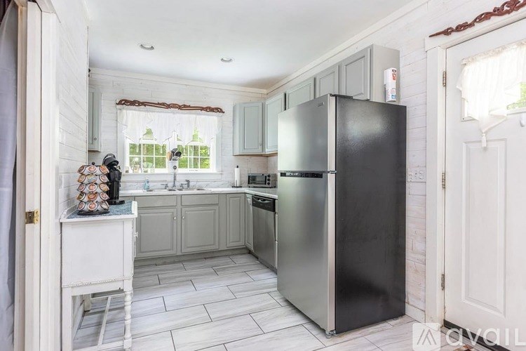 A kitchen with a black fridge and a white counter.