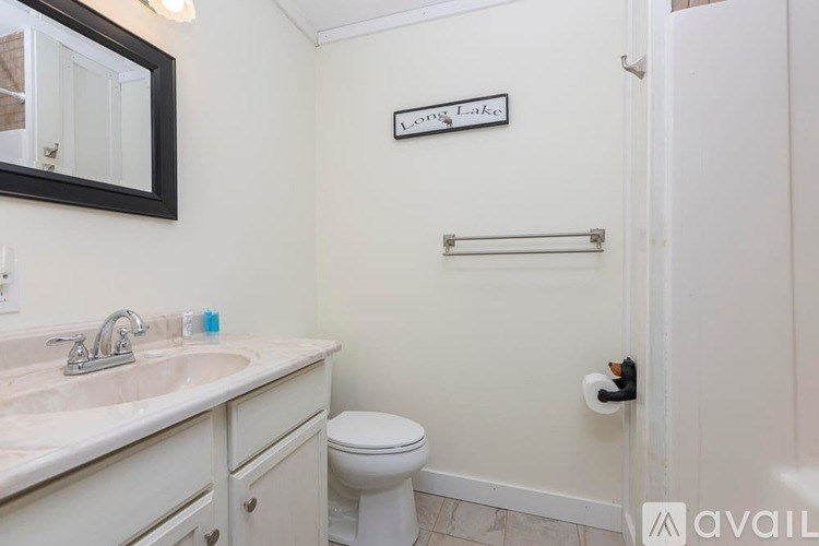 A bathroom with a toilet, sink, and a mirror.