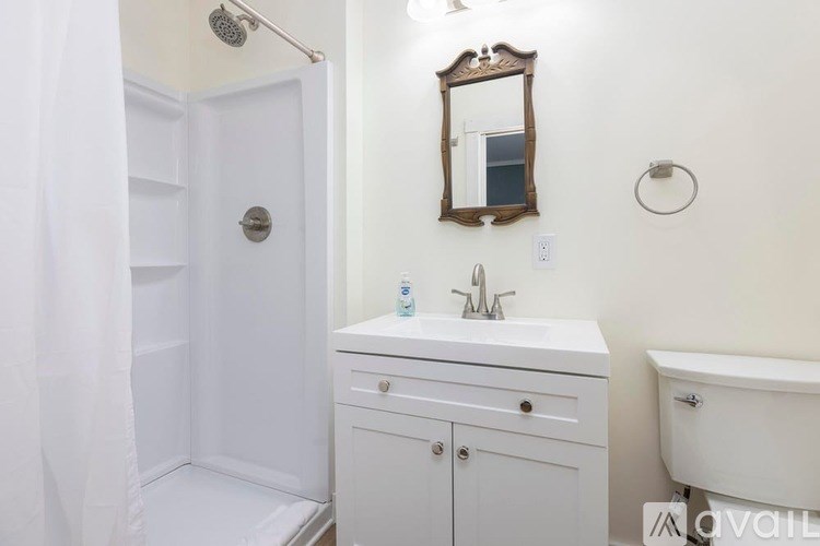 A white bathroom with a sink, mirror, and bathtub.