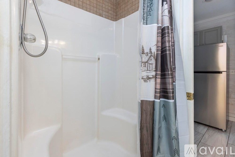 A shower area with a glass door and a shower head.