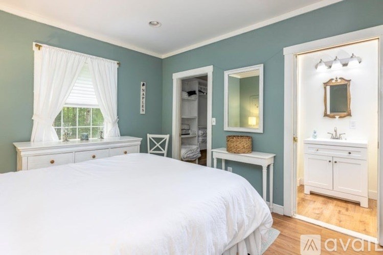A bedroom with a bed, dresser, and mirror.