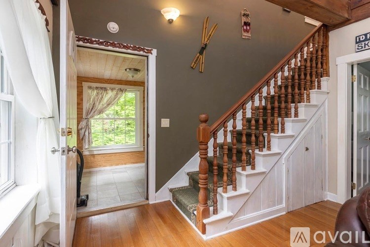 A wooden staircase with a white railing and a sign that says "TO SKY" above it.