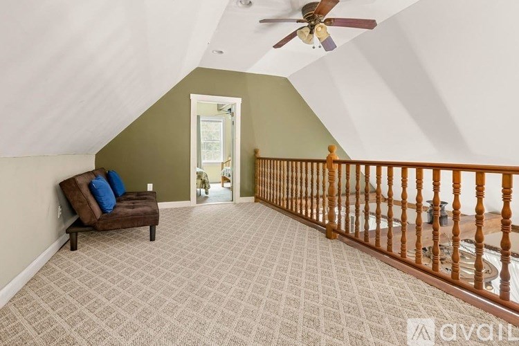 A living room with a couch and a ceiling fan.