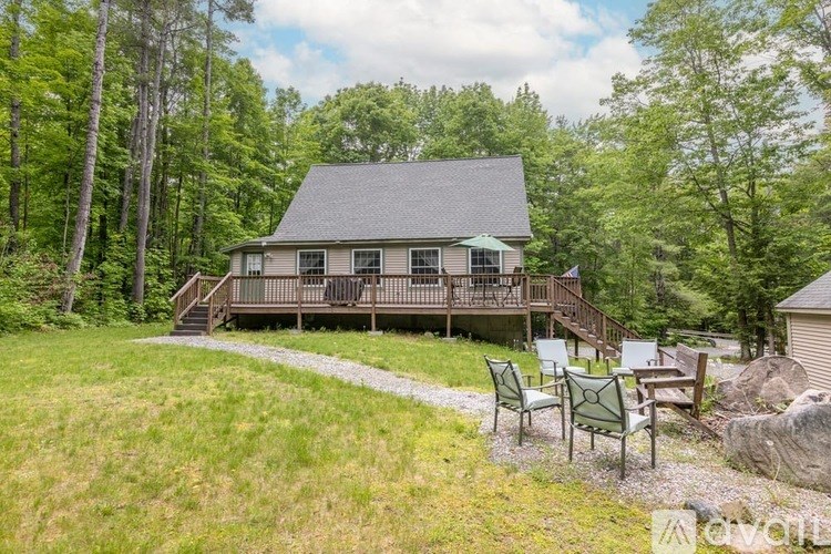 A house with a deck and patio furniture in a grassy area.