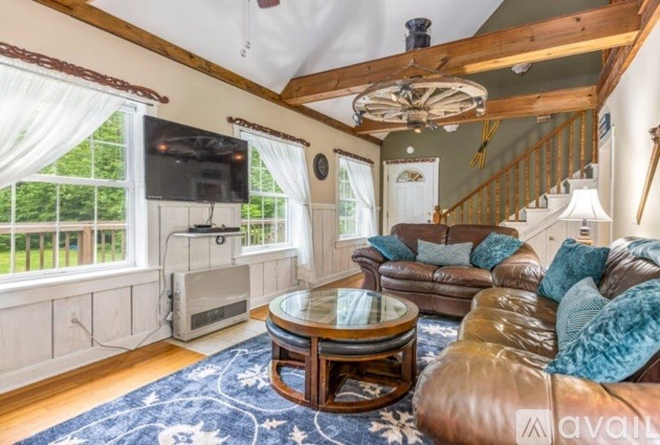 A living room with a brown leather couch and a glass coffee table.
