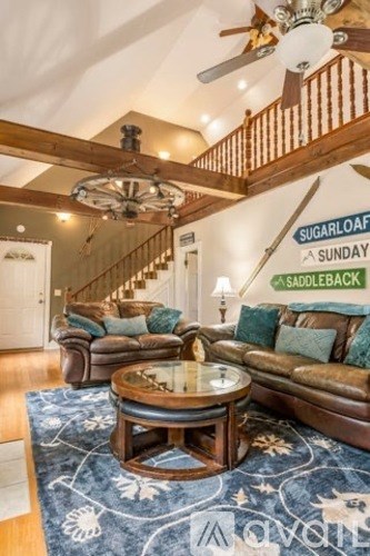 A living room with a couch, coffee table, and staircase.