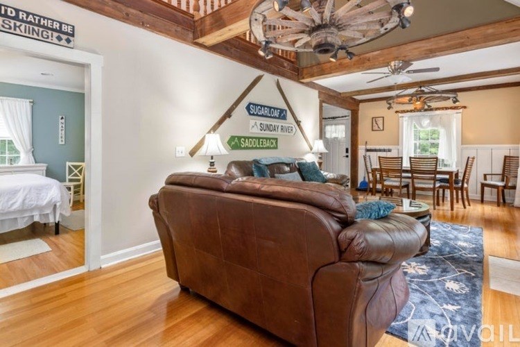 A living room with a brown couch and a ceiling fan.