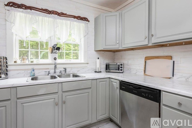A kitchen with a sink, a window, and a microwave.