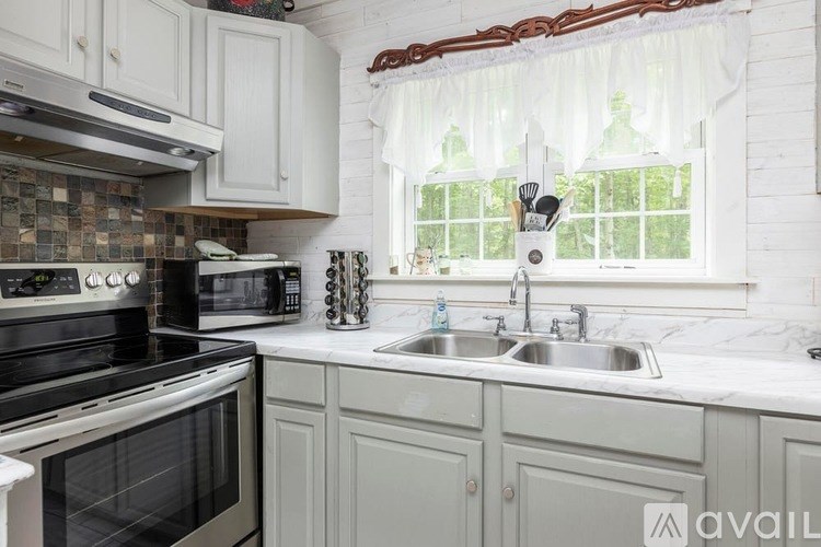 A kitchen with a black stove top oven and a white microwave.