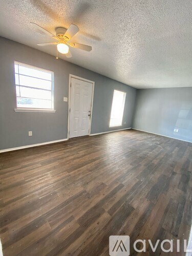 A room with wooden flooring and a ceiling fan.