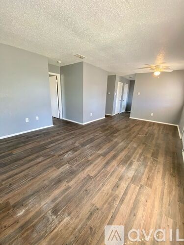 A room with wooden flooring and a ceiling fan.