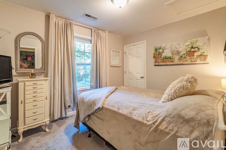 A bedroom with a large bed and a dresser with a mirror.