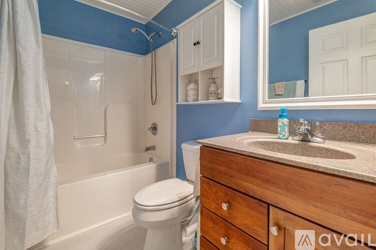 A bathroom with blue walls and a white toilet.