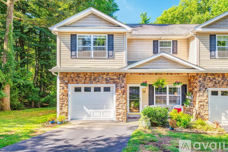 A house with a stone pillar on the front and two garages.