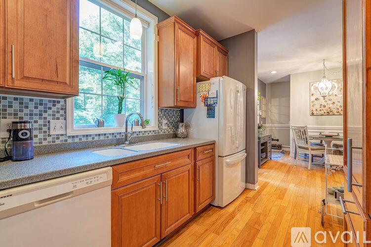 A kitchen with wooden cabinets and a white fridge.
