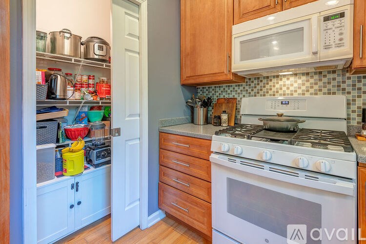 A kitchen with a white stove and wooden cabinets.