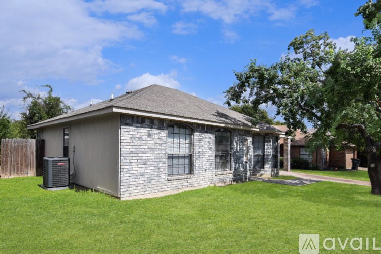 A tree in front of a house with a sign that says "available".
