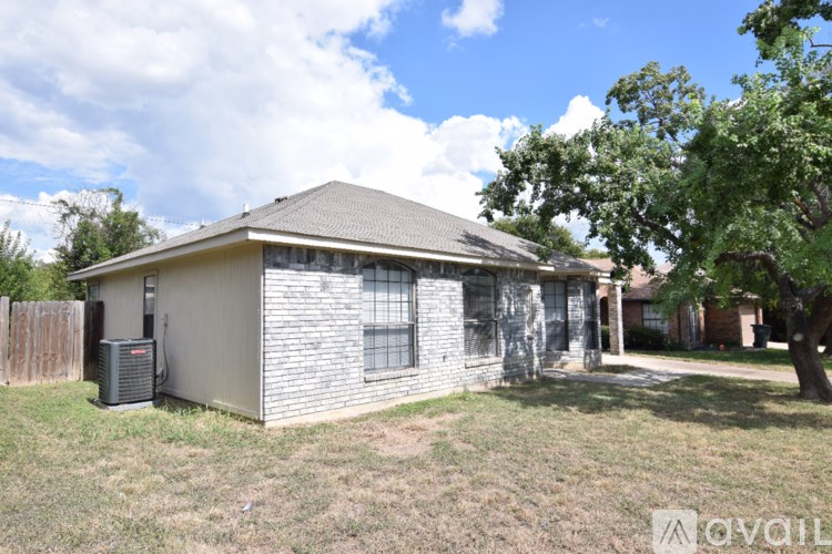 A house with a gray roof and a tree in front.